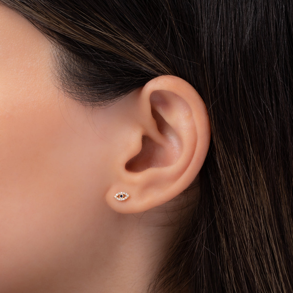 Tiny Diamond Evil Eye Stud Earring shown on ear for scale