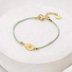 Aqua cord Tiny Hamsa Bracelet with gold-plated Hamsa charm by Shlomit Ofir