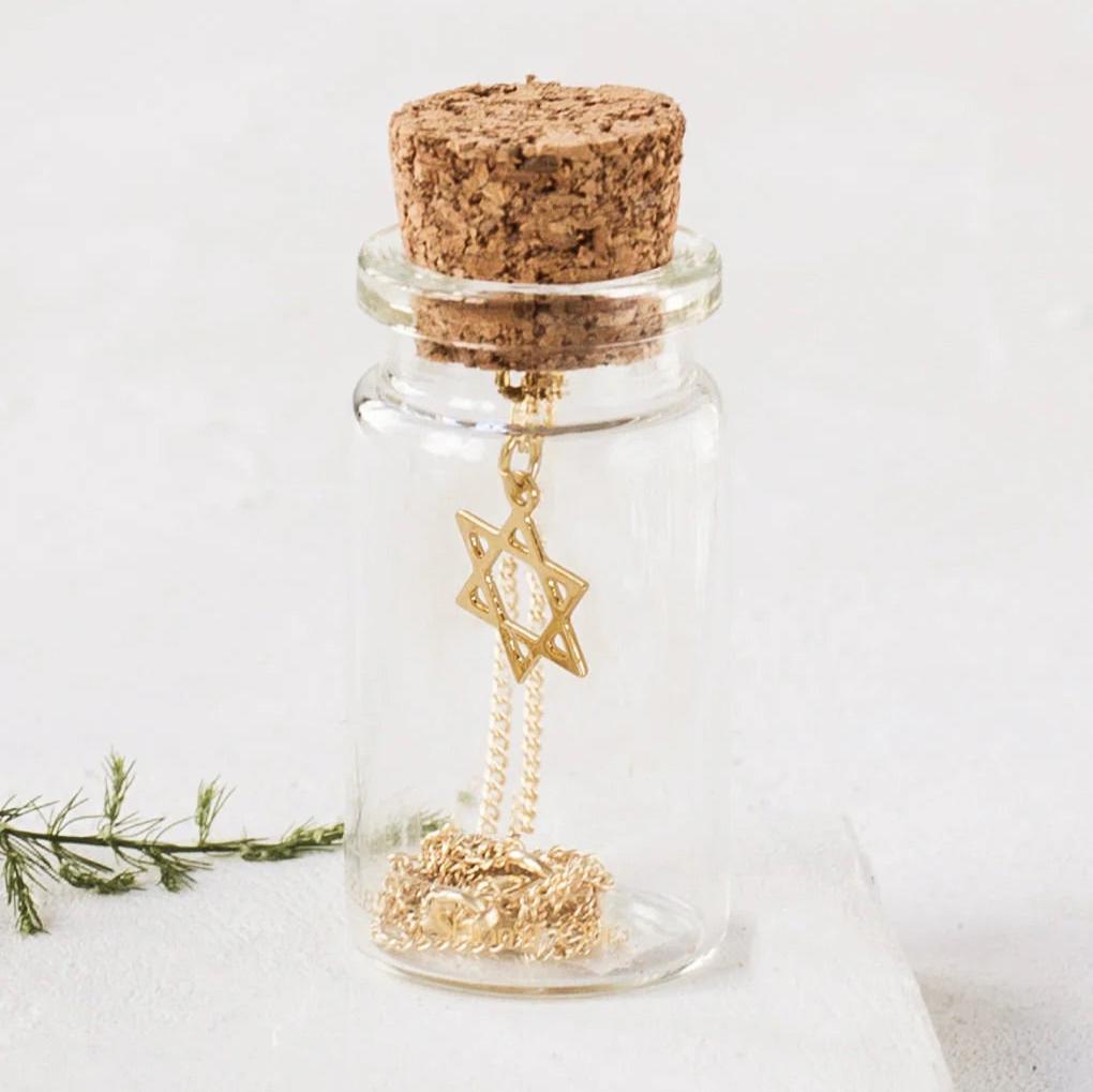 Tiny Star of David Necklace displayed in a glass gift bottle