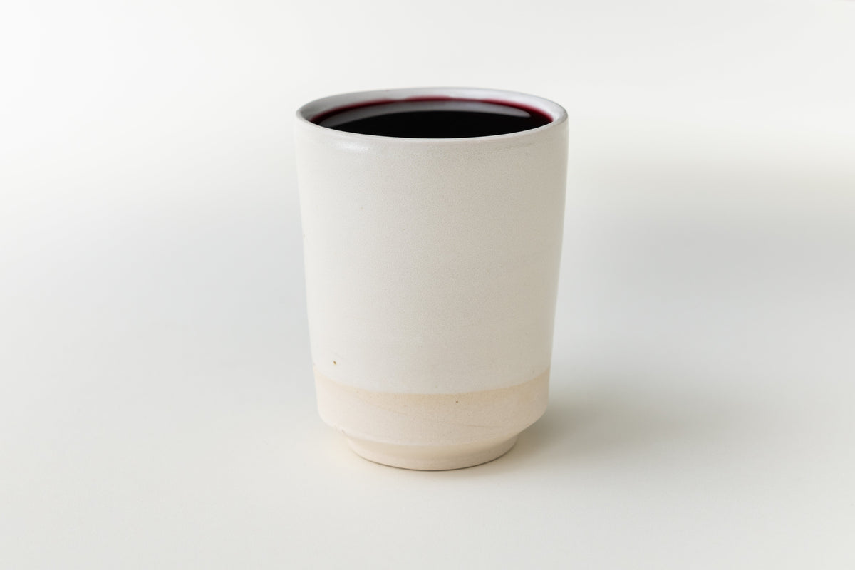 White ceramic Kiddush cup with wine by Oneg