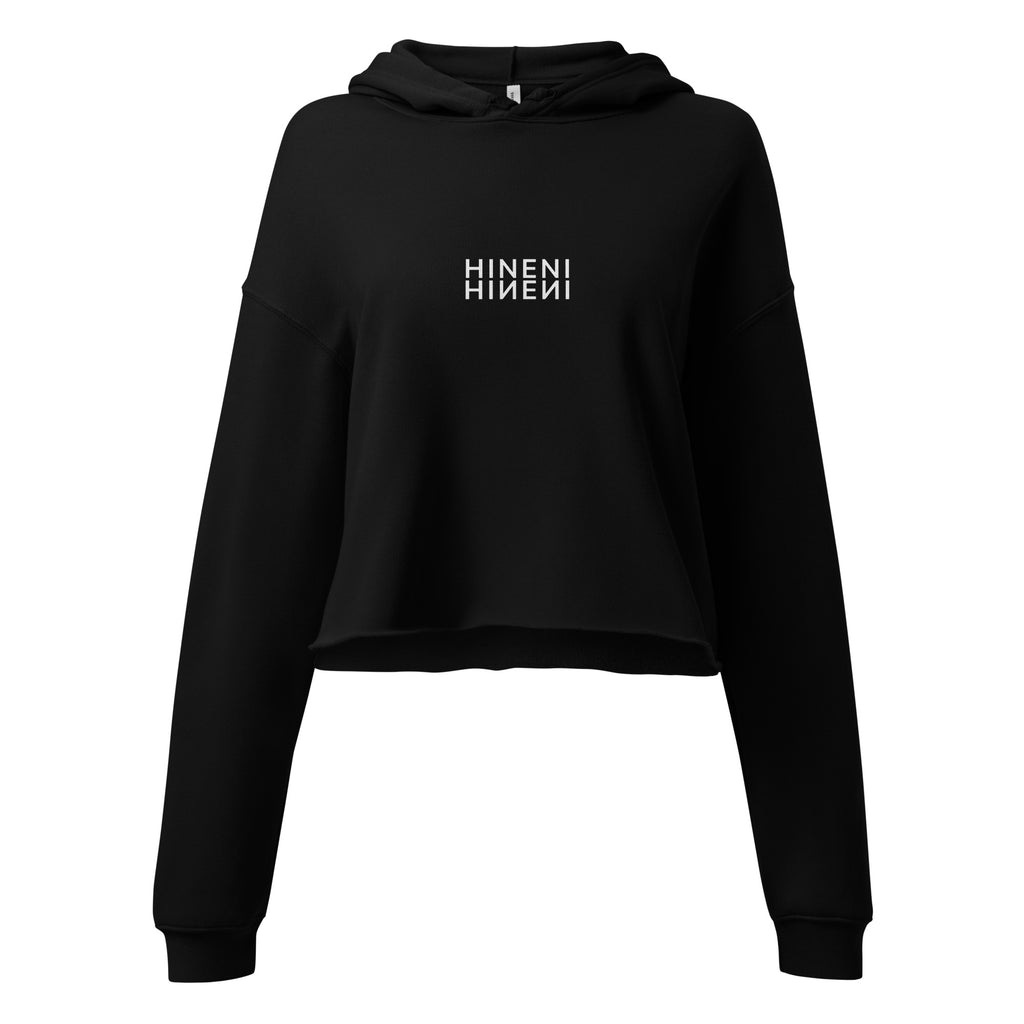 HINENI women's cropped hoodie in Black with white mirrored lettering on the chest, dropped shoulders, and a raw-edge hem.